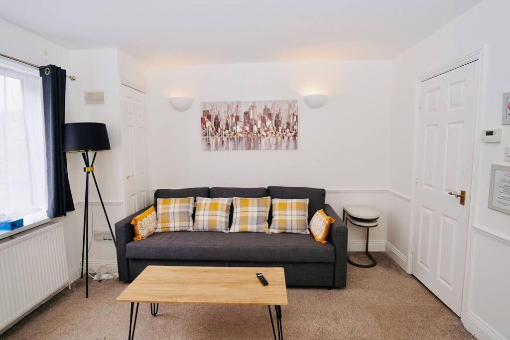 een woonkamer met een bank en een tafel bij Spacious 1 Bed Flat in Central Slough in Slough