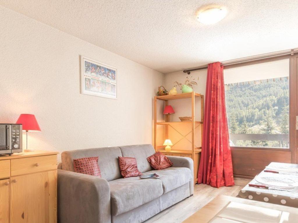 un salon avec un canapé et une fenêtre dans l'établissement Studio lumineux 4 pers., balcon sud, parking - Serre-Chevalier - FR-1-330E-50, à Saint-Chaffrey