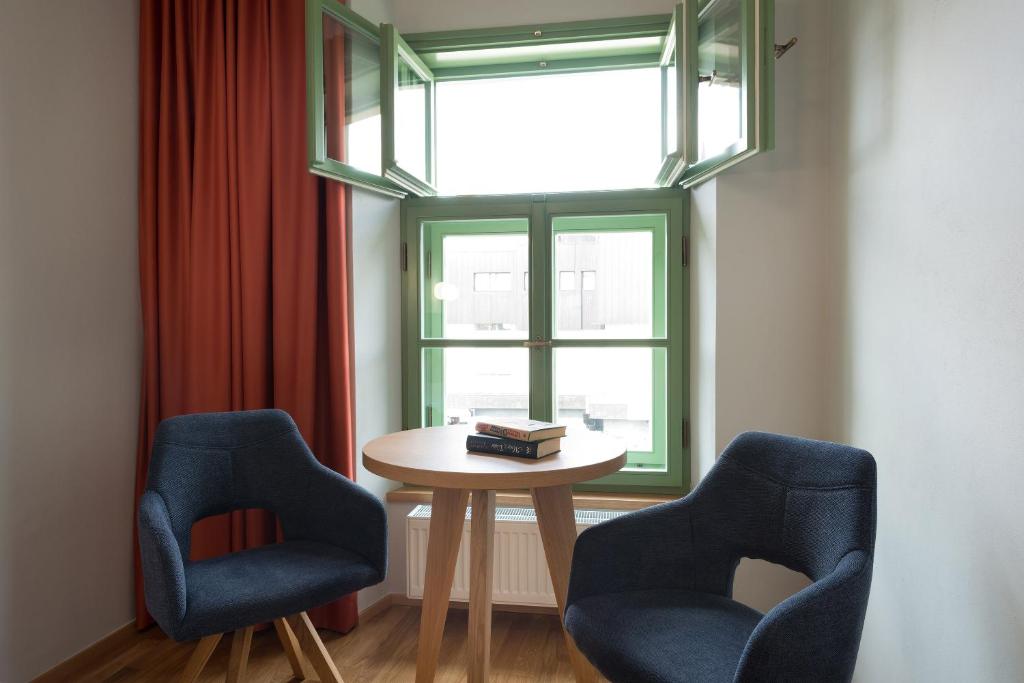 2 stoelen en een tafel in een kamer met een raam bij Hotel Tři knížata in Jihlava