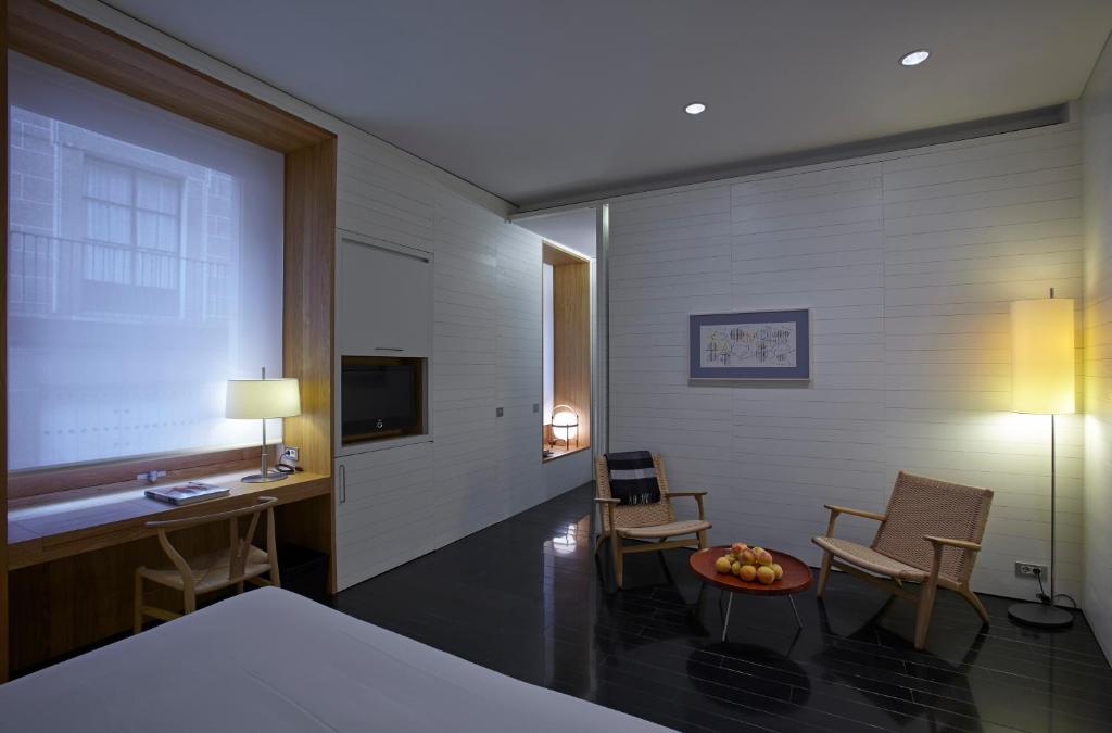 Cette chambre comprend un lit, un bureau et des chaises. dans l'établissement Atrio Restaurante Hotel 5 Estrellas - 3 Llaves Michelan, à Cáceres