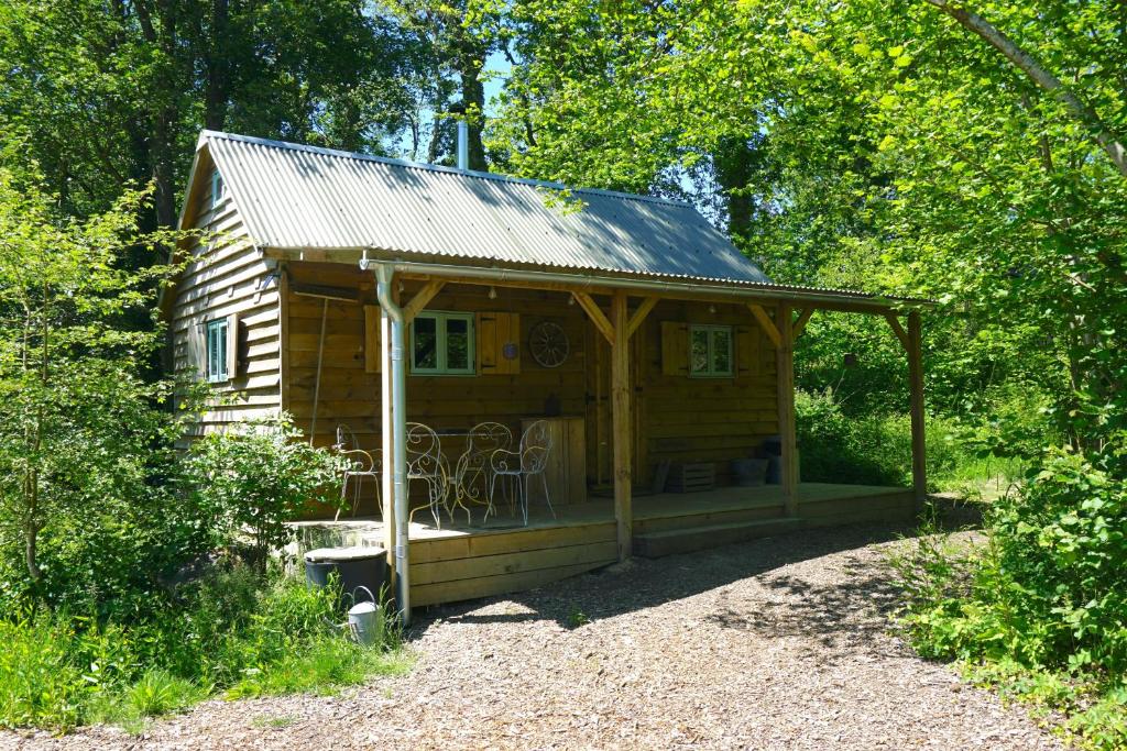 une petite cabane en bois avec un toit en métal dans l'établissement Forest Garden Shovelstrode, à East Grinstead
