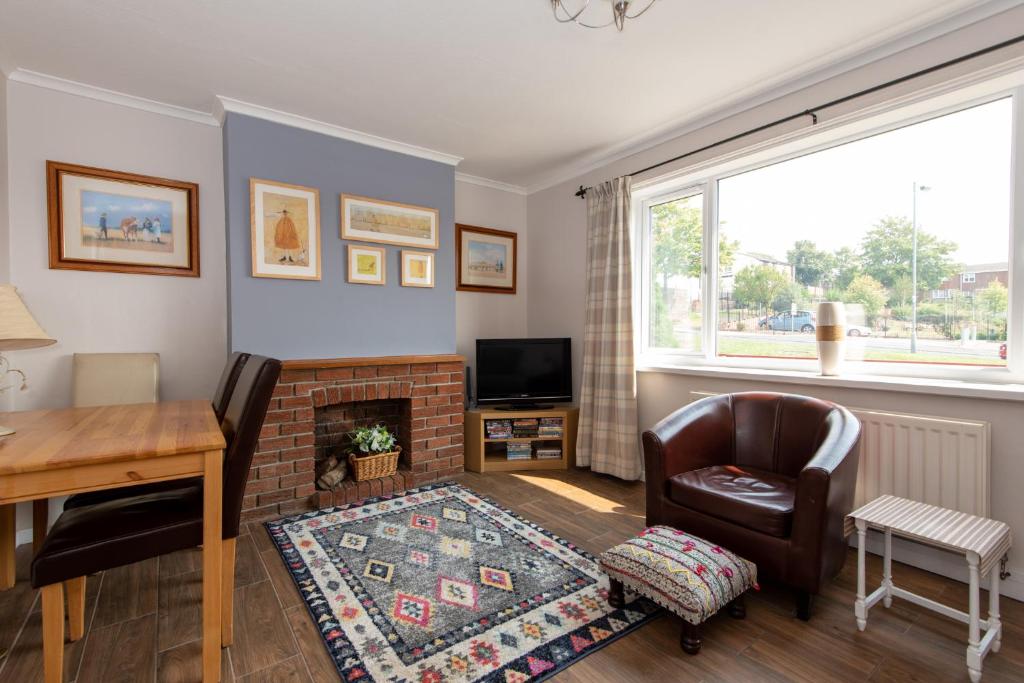 ein Wohnzimmer mit einem Kamin, einem Schreibtisch und einem Stuhl in der Unterkunft Pine Park in Ushaw Moor