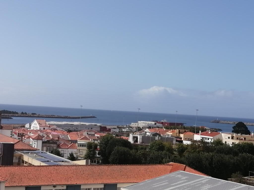 a city with houses and the ocean in the background at Portela - APARTAMENTO in Viana do Castelo