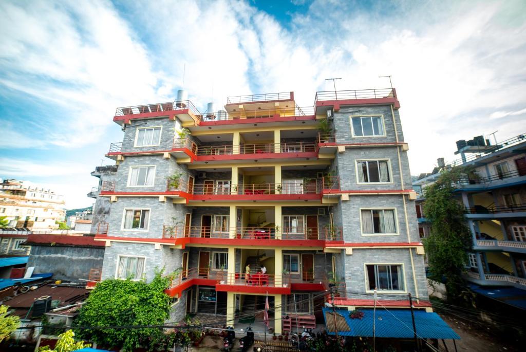 博卡拉Hotel Peace Stupa的一座高大的建筑,旁边设有阳台