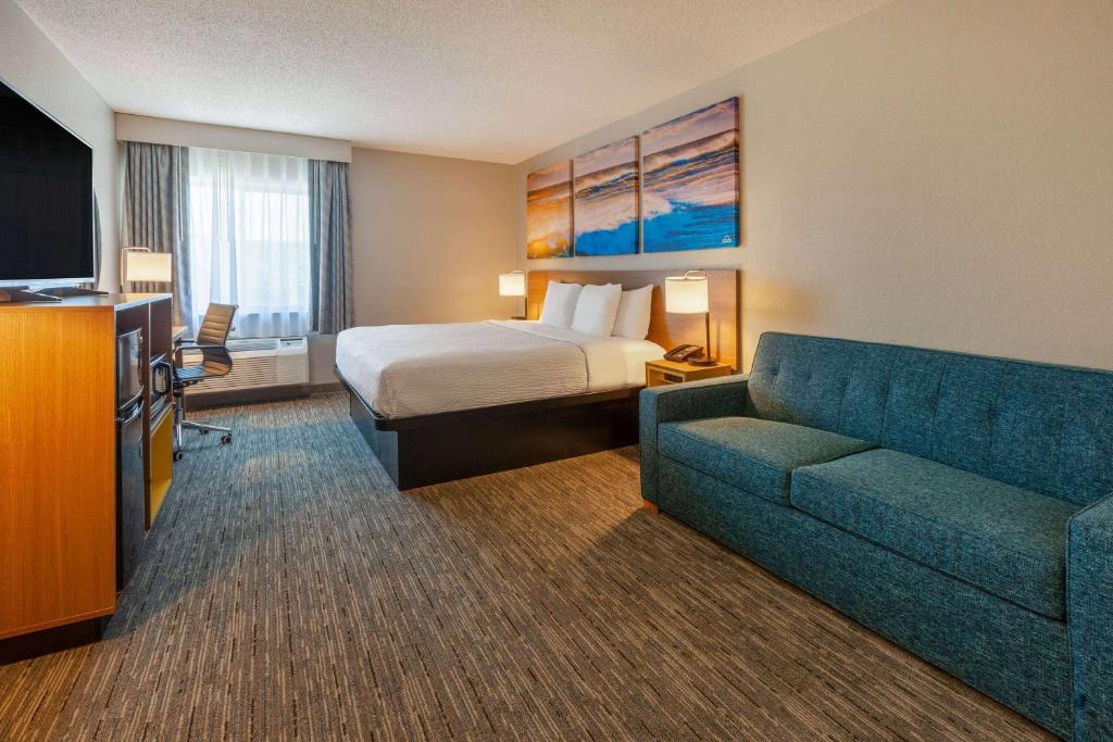um quarto de hotel com uma cama e um sofá em Days Inn by Wyndham Racine/Sturtevant em Sturtevant