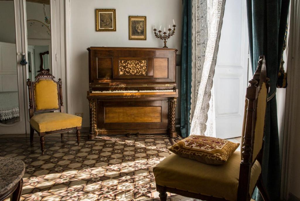 uma sala de estar com um piano e uma cadeira em Le Foglie Di Acanto em Lucera