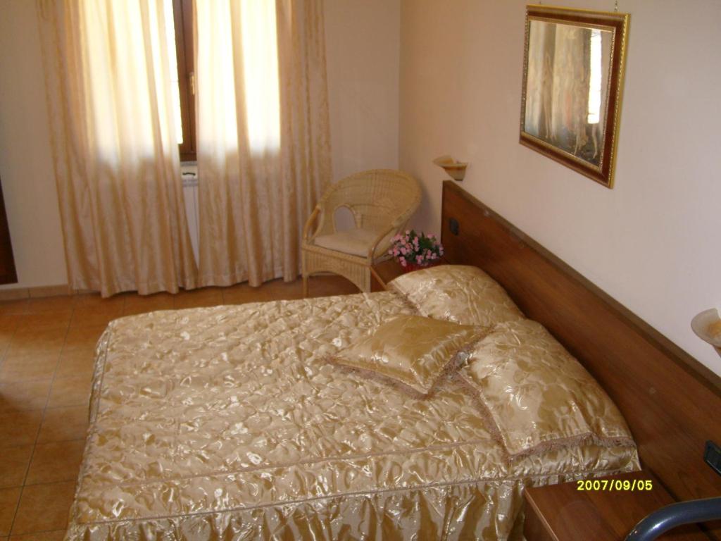 una camera con un grande letto con testiera in legno di HOTEL RISTORANTE DEGLI AMICI a Mongiana