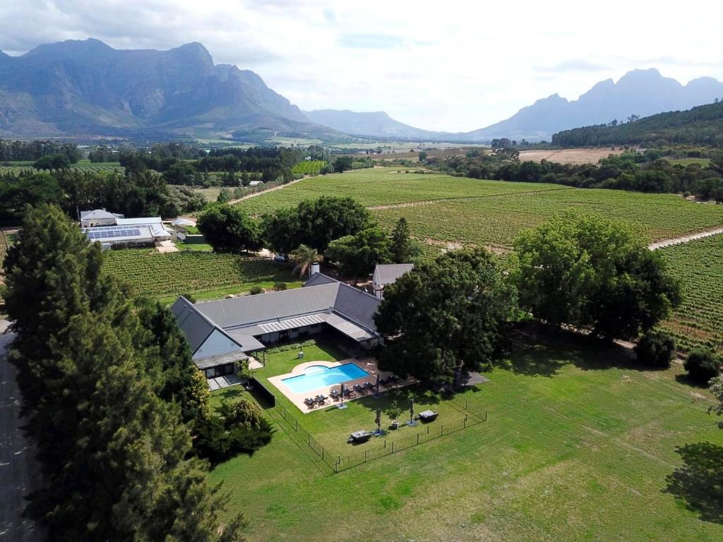 Franschhoek的住宿－Lynx Wine Estate，享有带游泳池的田野房屋的空中景致