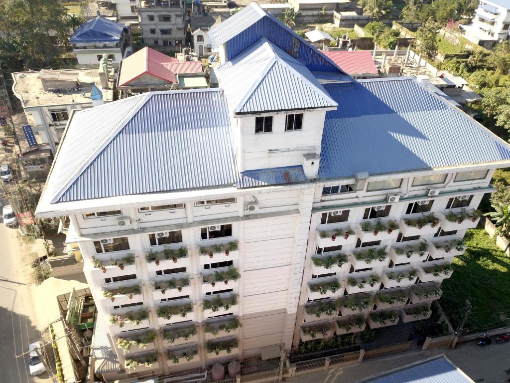 an overhead view of a white building with a blue roof at Hotel Tea County in Dibrugarh