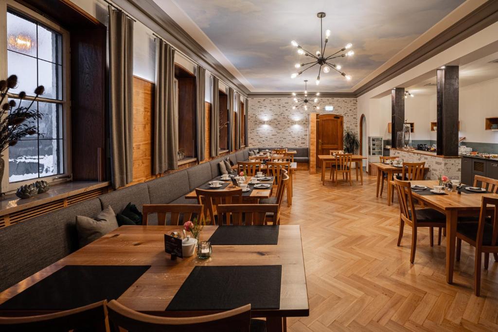a restaurant with wooden tables and chairs and windows at Hotel Zu den Drei Kronen in Donauwörth