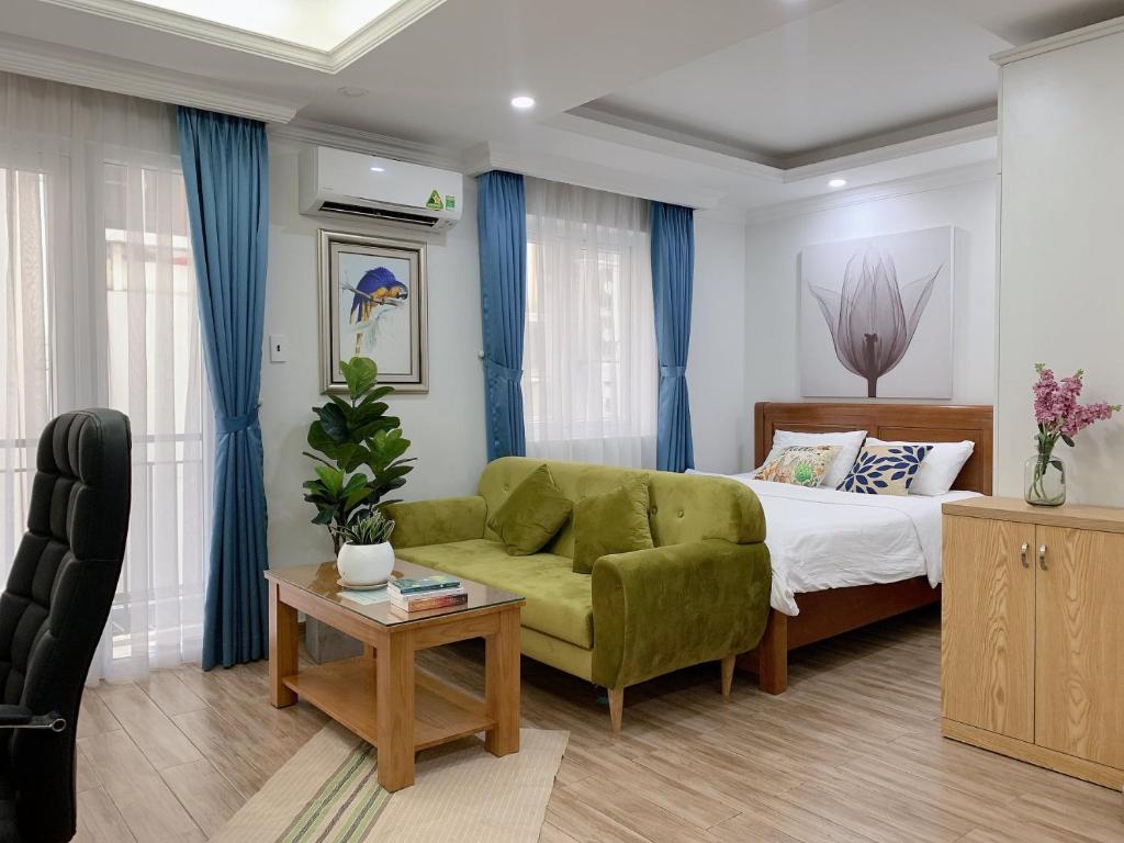 1 dormitorio con sofá verde y cama en Atlas Hotel & Apartments, en Ho Chi Minh