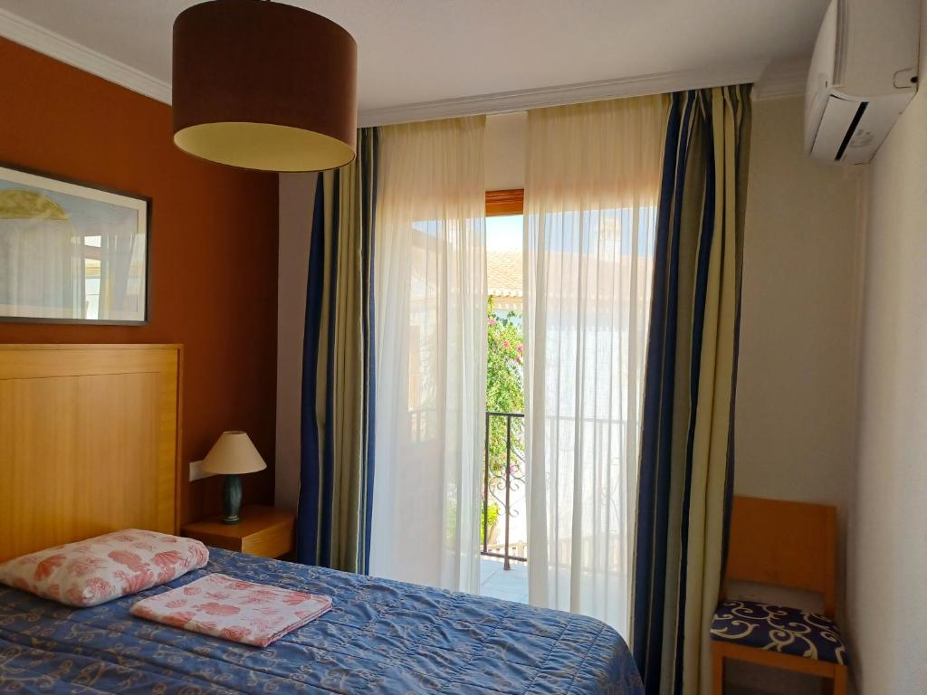 een slaapkamer met een bed en een groot raam bij Apartamento Oasis in Playas de Vera