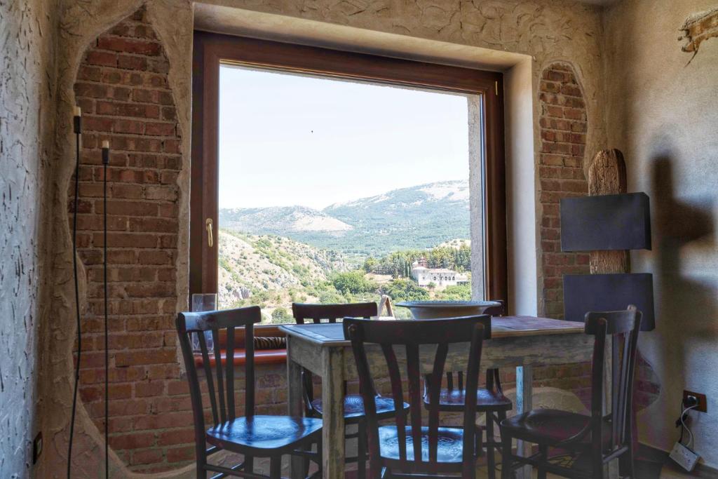 einen Tisch und Stühle in einem Zimmer mit Fenster in der Unterkunft Bella Vista in Atena Lucana