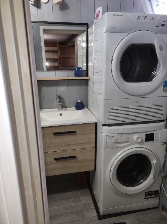 a bathroom with a washing machine and a sink at Studio indépendant dans un maison in Saint-Denis