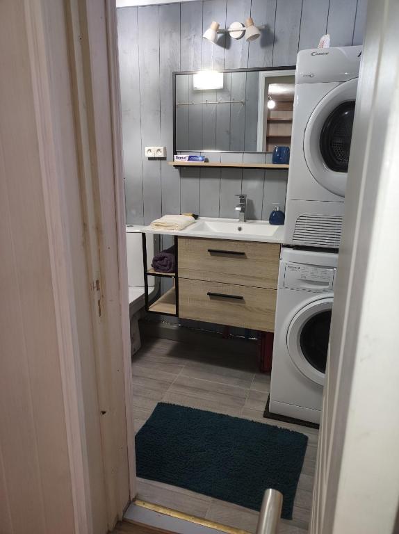 a kitchen with a washing machine and a sink at Studio indépendant dans un maison in Saint-Denis
