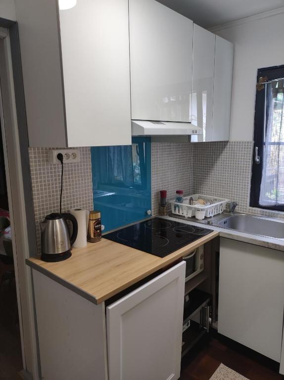 a kitchen with white cabinets and a black counter top at Studio indépendant dans un maison in Saint-Denis