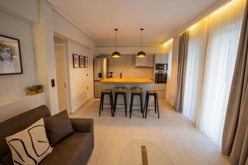 ein Wohnzimmer und eine Küche mit einem Sofa und einem Tisch in der Unterkunft Vallia Suites - Luxury Suite in Nafpaktos