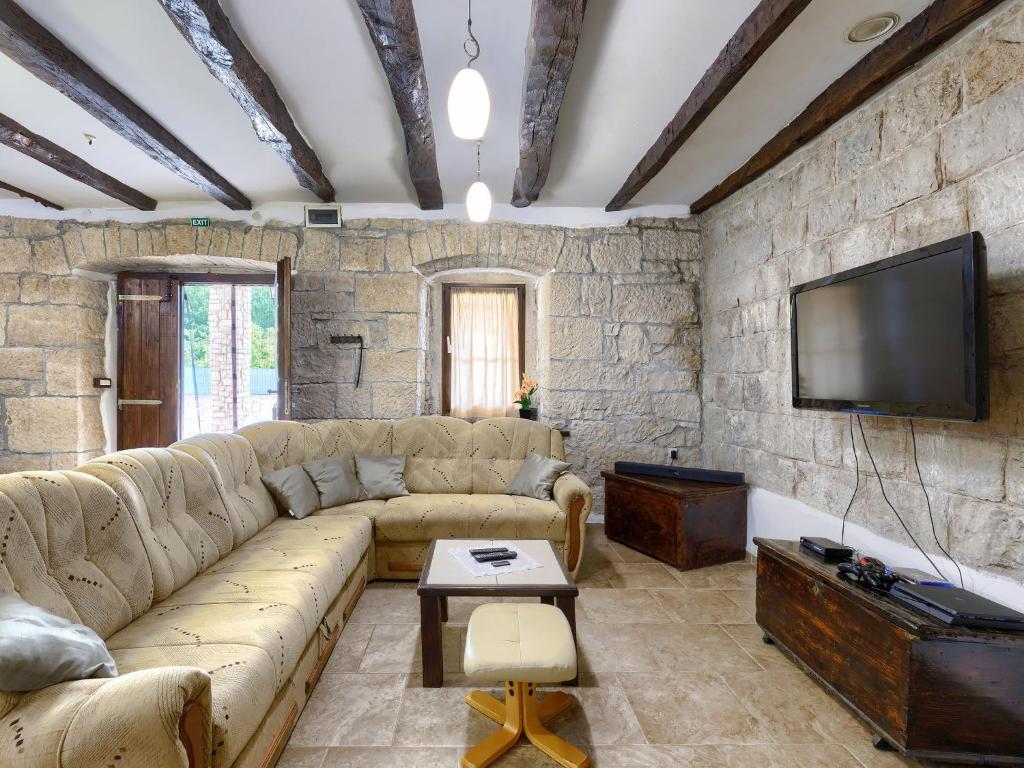 a living room with a couch and a flat screen tv at Holiday Home Šterna by Interhome in Brajkovići