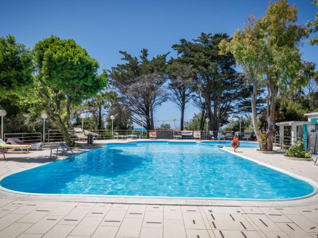 a large swimming pool with trees in the background at Holiday Home Miramare-3 by Interhome in Antignano