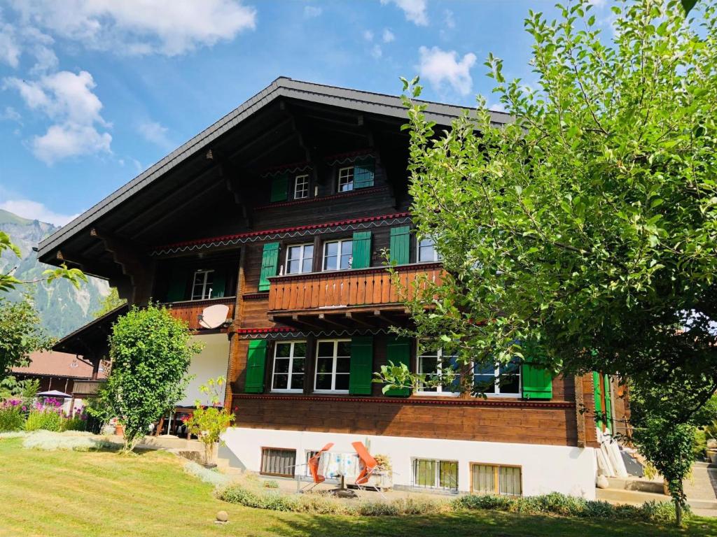 a wooden house with green and white at Apartment Träumli by Interhome in Lenk