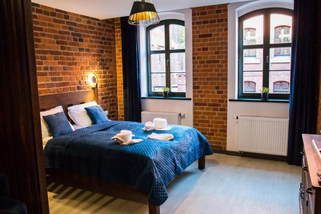 - une chambre dotée d'un lit bleu avec deux plats dans l'établissement Miodowa Faktoria 5, à Toruń