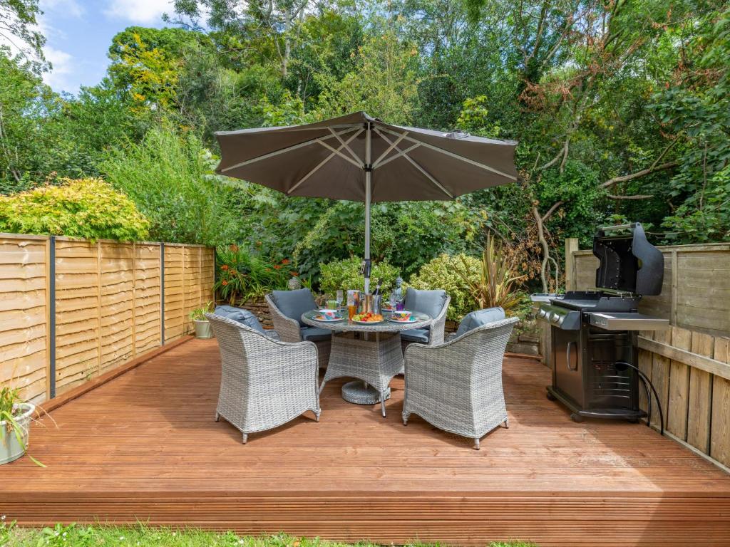 a patio with a table and chairs and an umbrella at Holiday Home Sea Echo by Interhome in St Austell