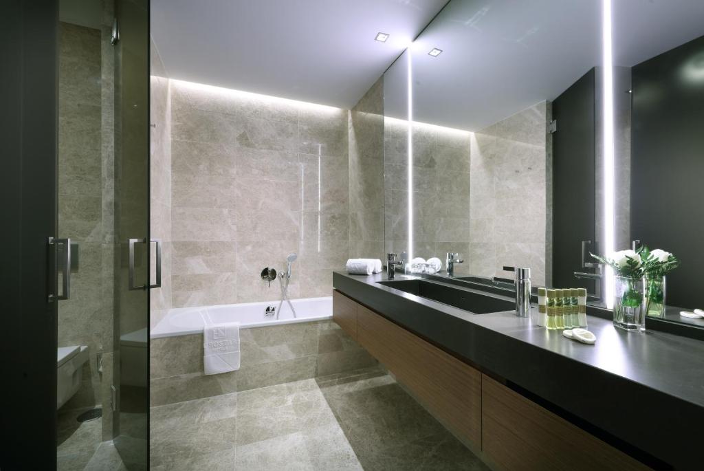 a bathroom with a black sink and a tub at Eurostars Torre Sevilla in Seville