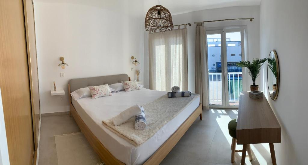 ein Schlafzimmer mit einem großen Bett und einem Balkon in der Unterkunft AmuraHouse. Private terrace BBQ. Centric and cosy. in Cotillo