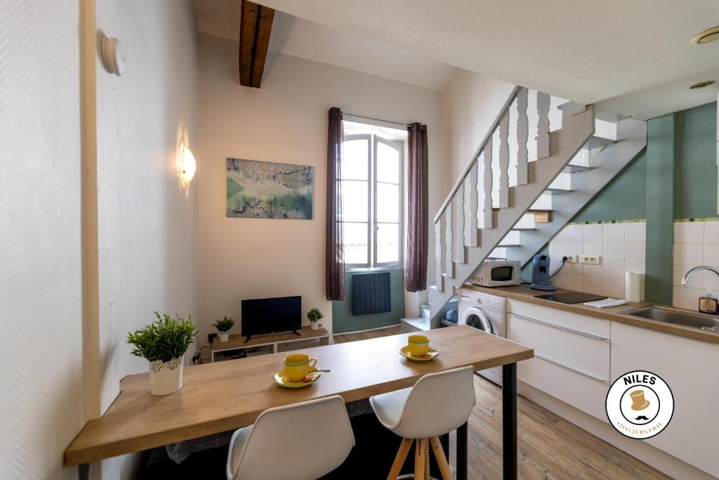 kuchnia i jadalnia ze stołem i krzesłami w obiekcie Le P'ti Pau - Centre de Pau - Appartement lit double w mieście Pau