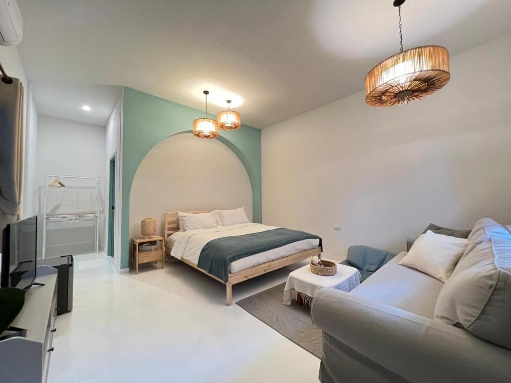 ein Wohnzimmer mit einem Bett und einem Sofa in der Unterkunft Warm White Hua Hin House in Hua Hin