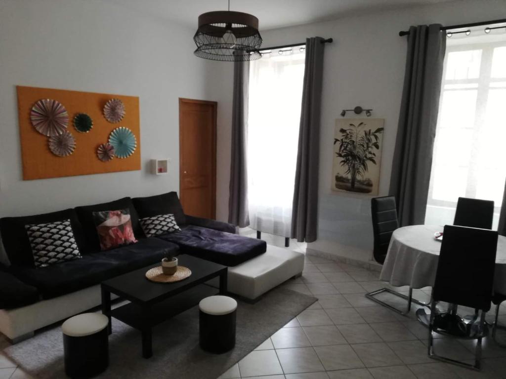 a living room with a couch and a table at Orange: appartement pratique et idéalement placé in Orange