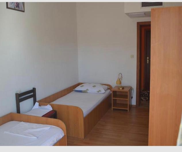 a small bedroom with two beds and a table at Plava kuća in Međugorje