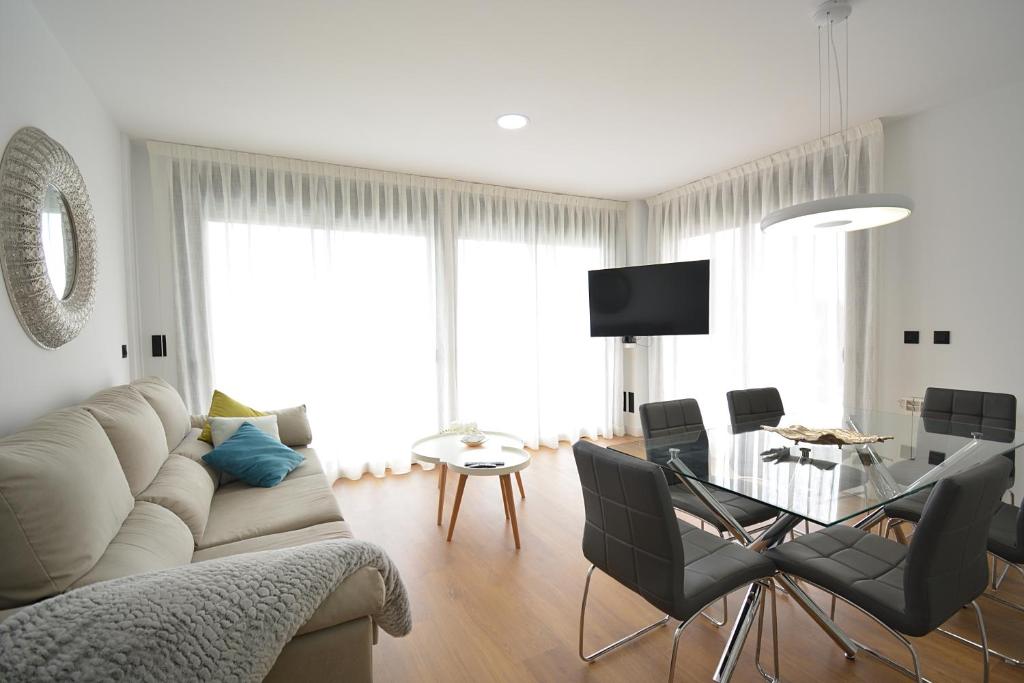 salon z kanapą i szklanym stołem w obiekcie GALIHOST - Apartamento con piscina en Canelas, Sanxenxo w mieście Sanxenxo