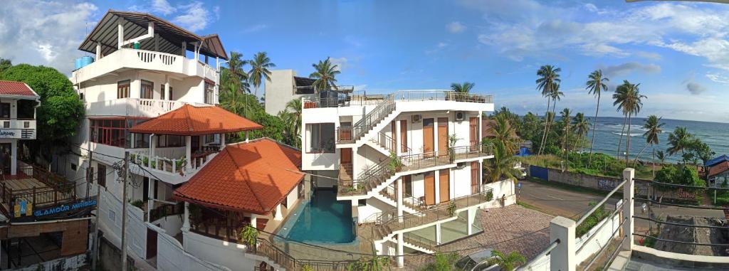 a group of buildings next to the ocean at Resort Deepika Mirissa in Mirissa