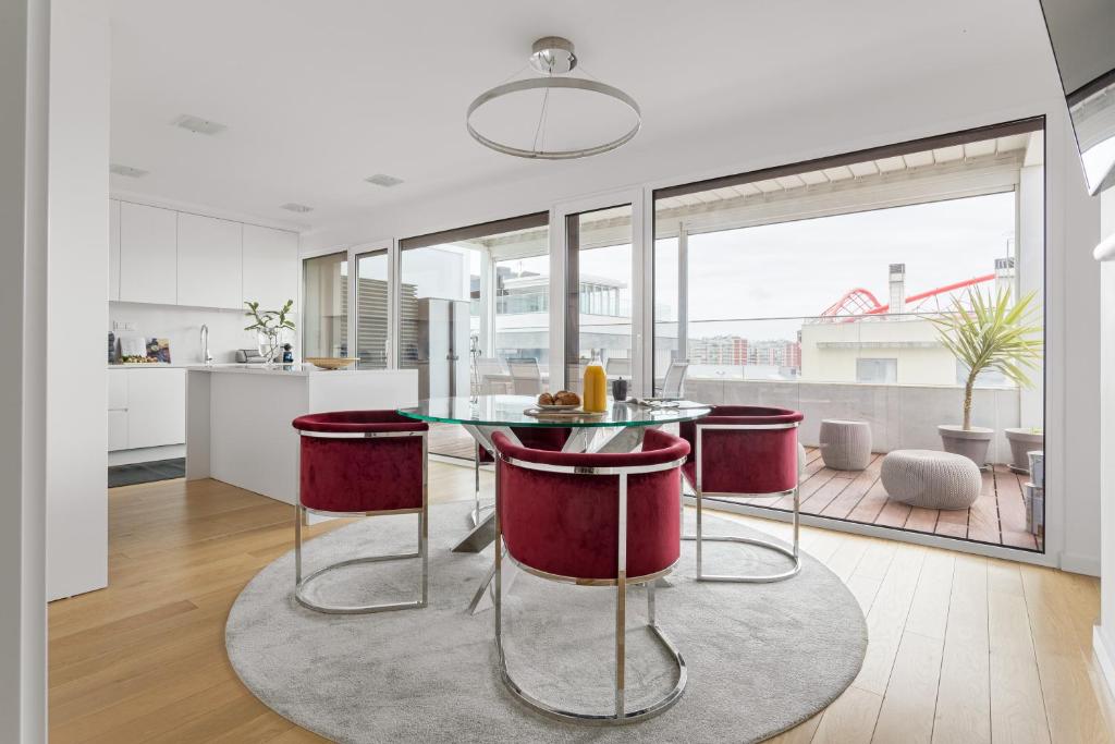 kuchnia i salon ze szklanym stołem i stołkami w obiekcie Modern 3BR with Terrace in Benfica w Lizbonie