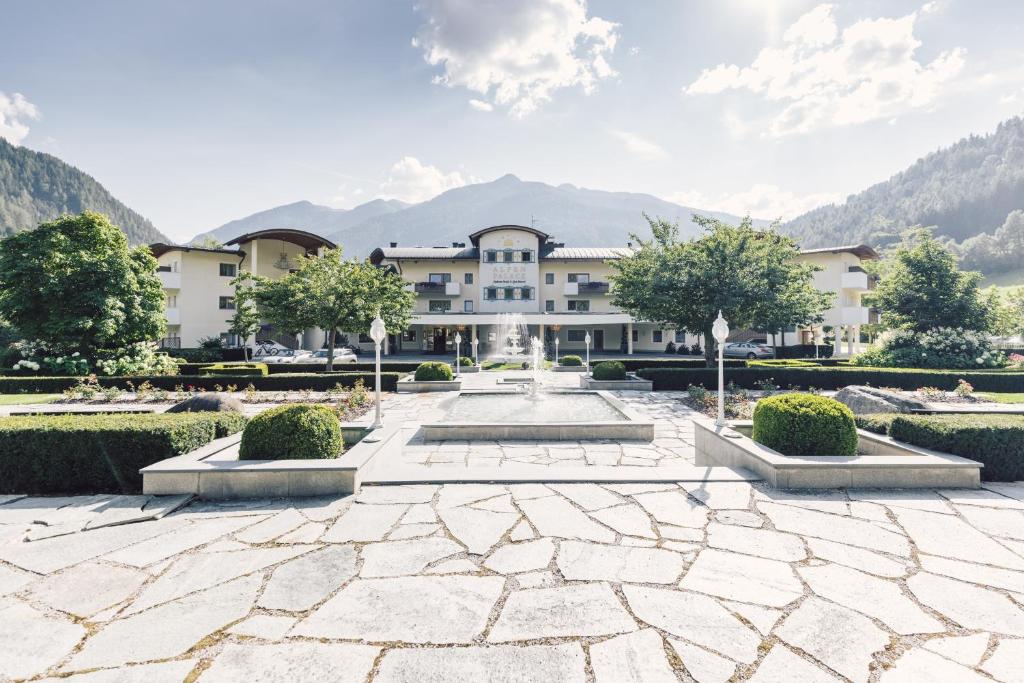 a large building with a courtyard with a fountain at Alpenpalace Luxury Hideaway & Spa Retreat in Lutago