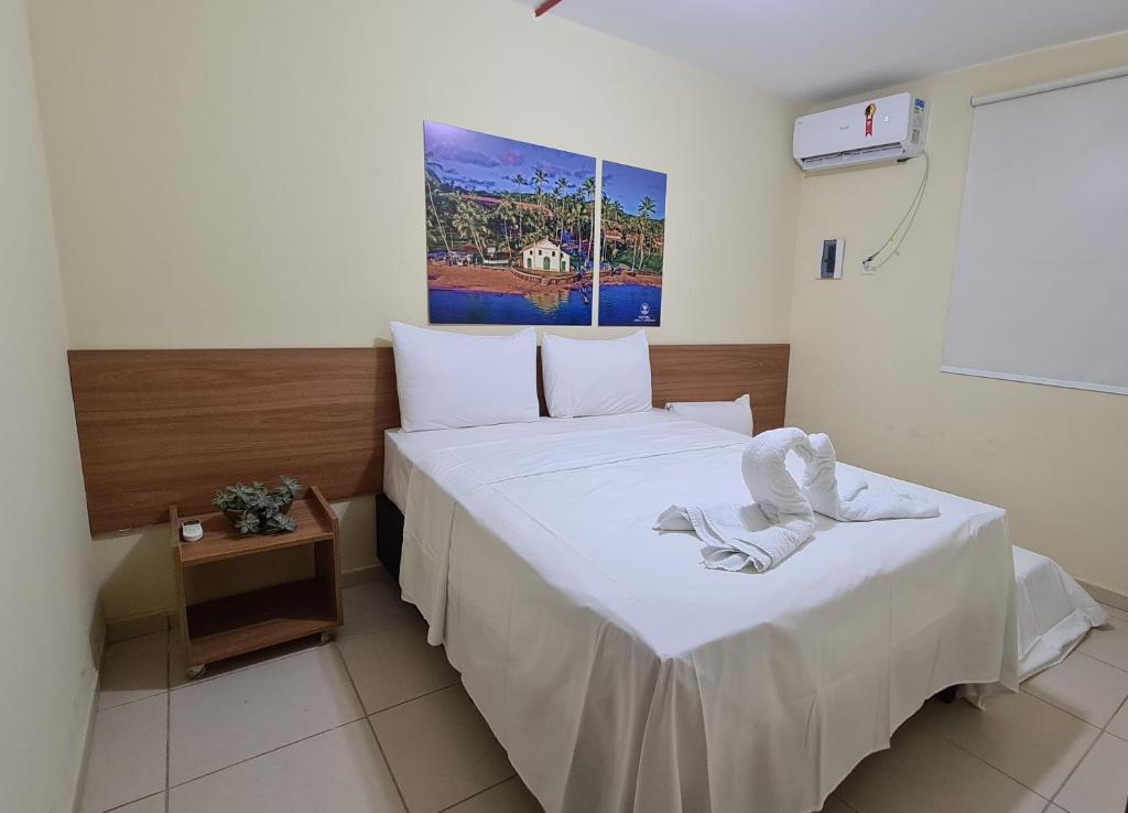 a hotel room with a bed with white sheets at Arena Carneiros Hotel by AFT in Tamandaré