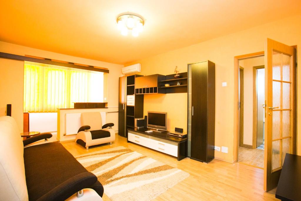 - un salon avec un canapé et une télévision dans l'établissement Sky Residence, à Bucarest