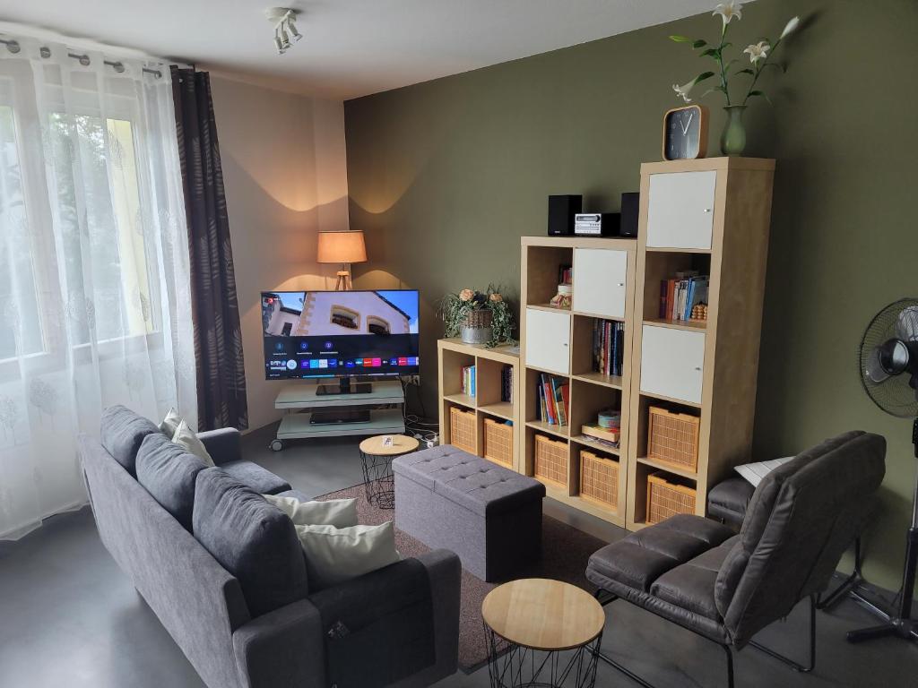 a living room with a couch and chairs and a tv at Ferienwohnung Burgblick in Wiesbaden