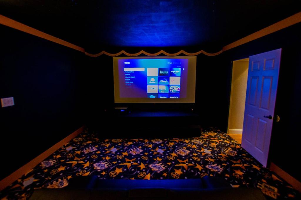 a dark room with a television and a bed with flowers at Lake Hamilton III Pool and Backyard Oasis with Kayaks Lake Access Theater in Winter Haven