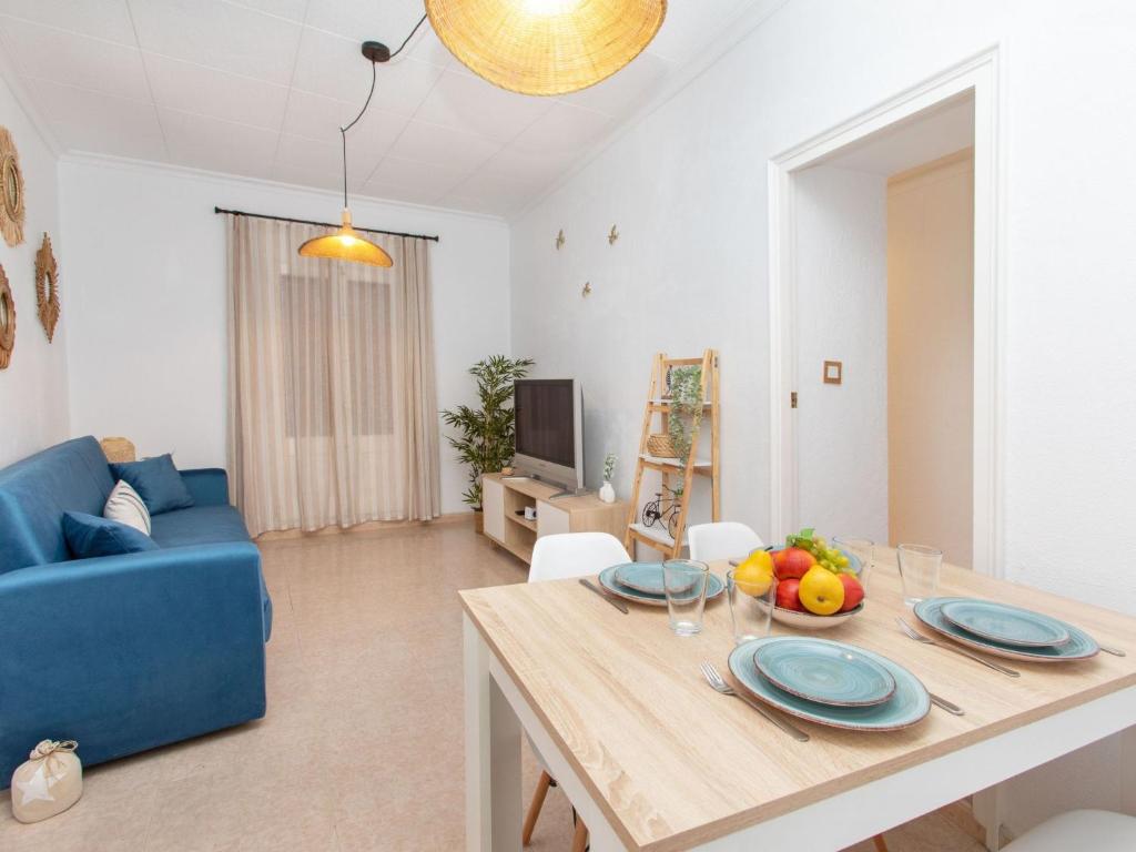 sala de estar con mesa y sofá azul en Apartment Portbou by Interhome, en Portbou