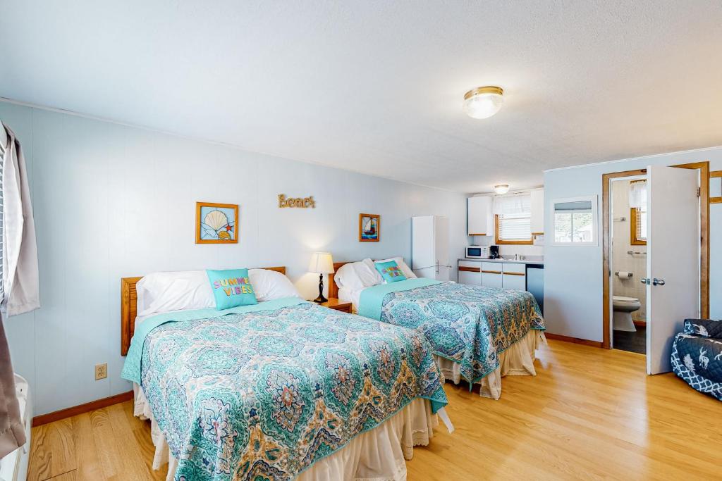 a bedroom with two beds and a kitchen at Coastal Calm A in Wells