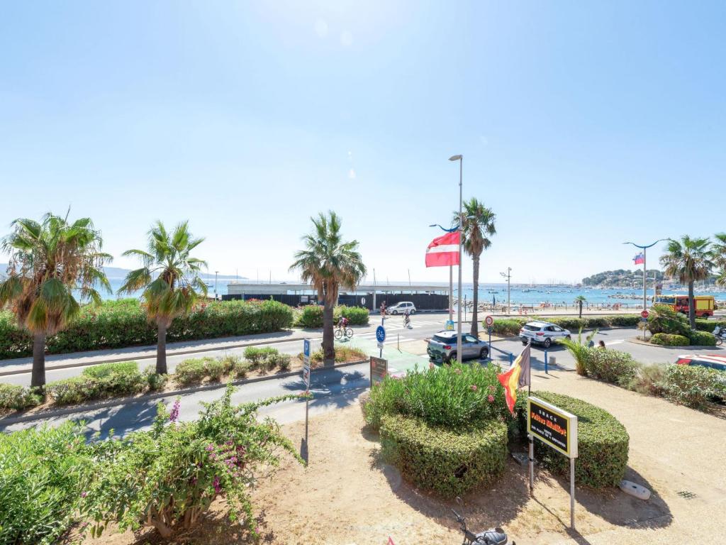 une vue sur un parc avec des palmiers et l'océan dans l'établissement Studio La Croix du Sud-27 by Interhome, à Cavalaire-sur-Mer