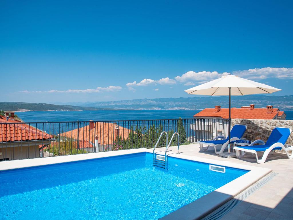 basen z 2 krzesłami i parasolem w obiekcie Holiday Home Villa Vali 2 by Interhome w mieście Vrbnik