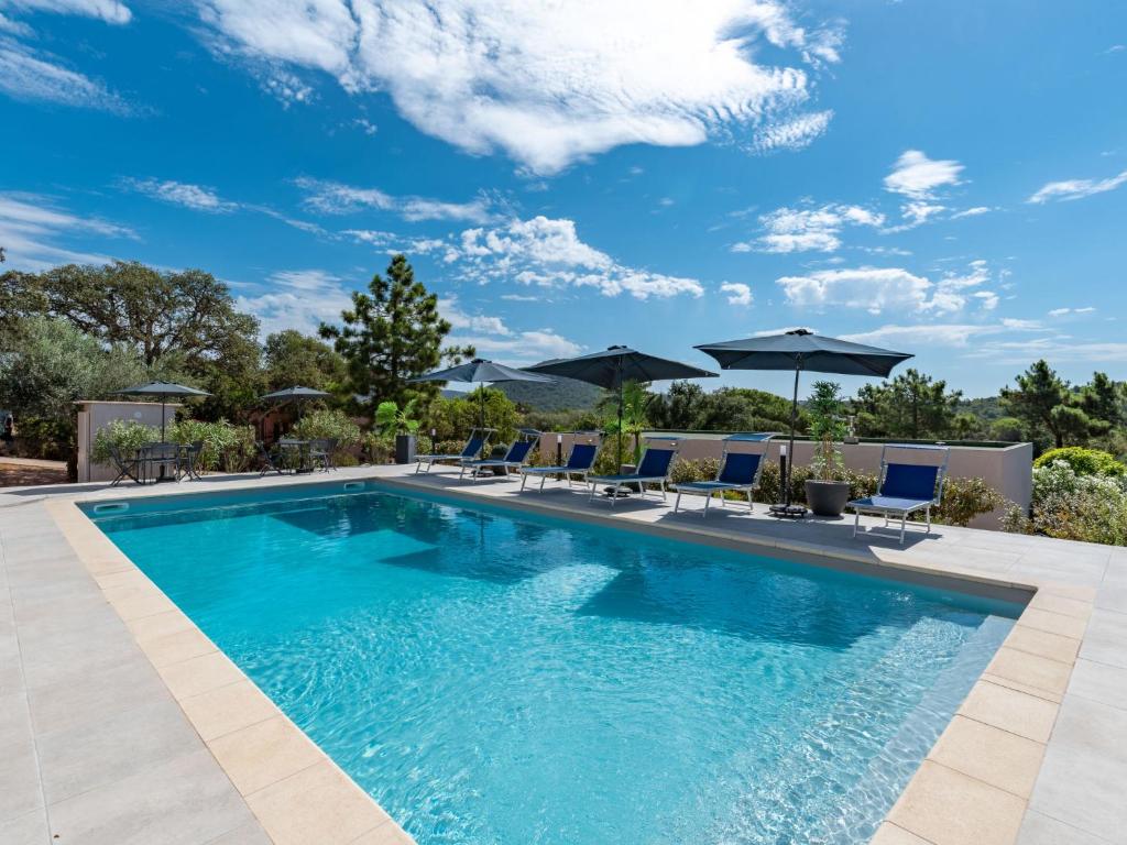 維琪奧港的住宿－Villa Villa Santa Reparata by Interhome，一个带蓝色椅子和遮阳伞的游泳池