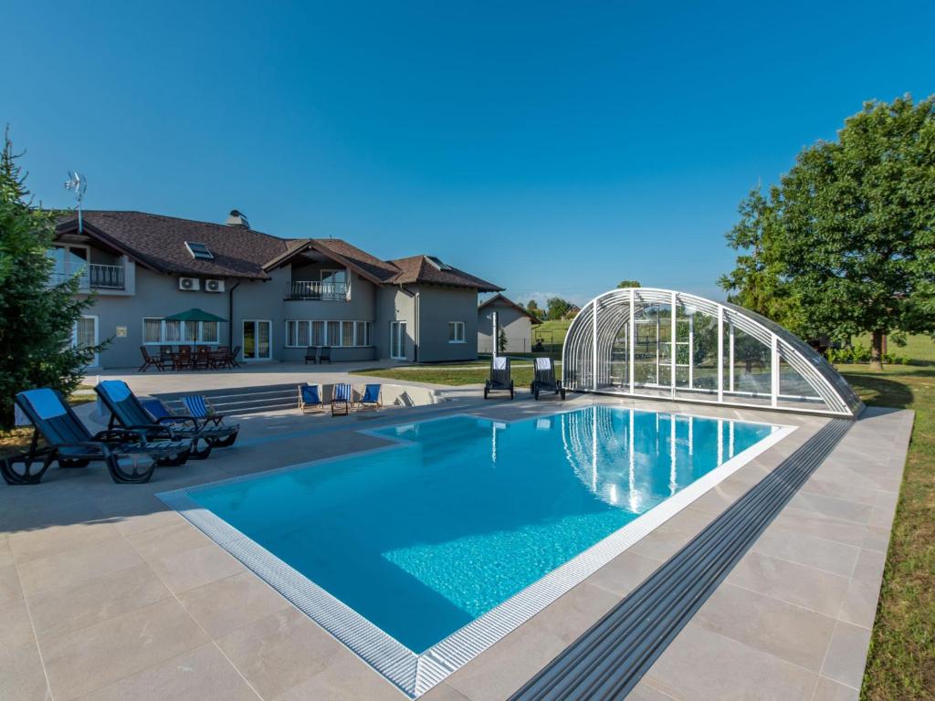 uma piscina com uma ponte e uma casa em Villa Adriana by Interhome em Ivanic-Grad