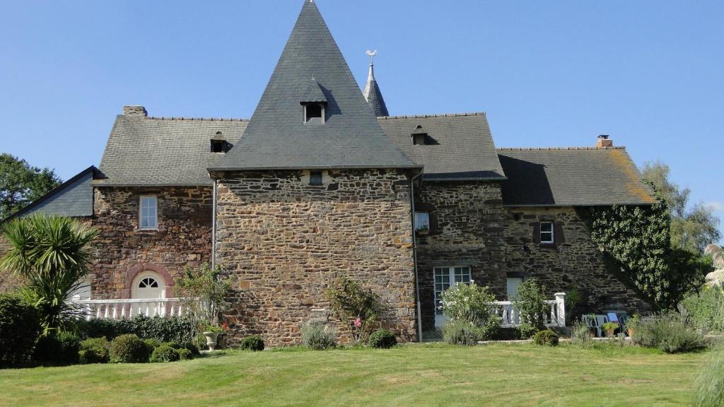 a large stone house with a roof at Manoir La Haie Chapeau in Saint-Thurial