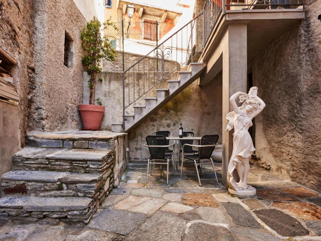 een standbeeld op een binnenplaats met een tafel en een trap bij Holiday Home Matilde e Melissa by Interhome in Naggio