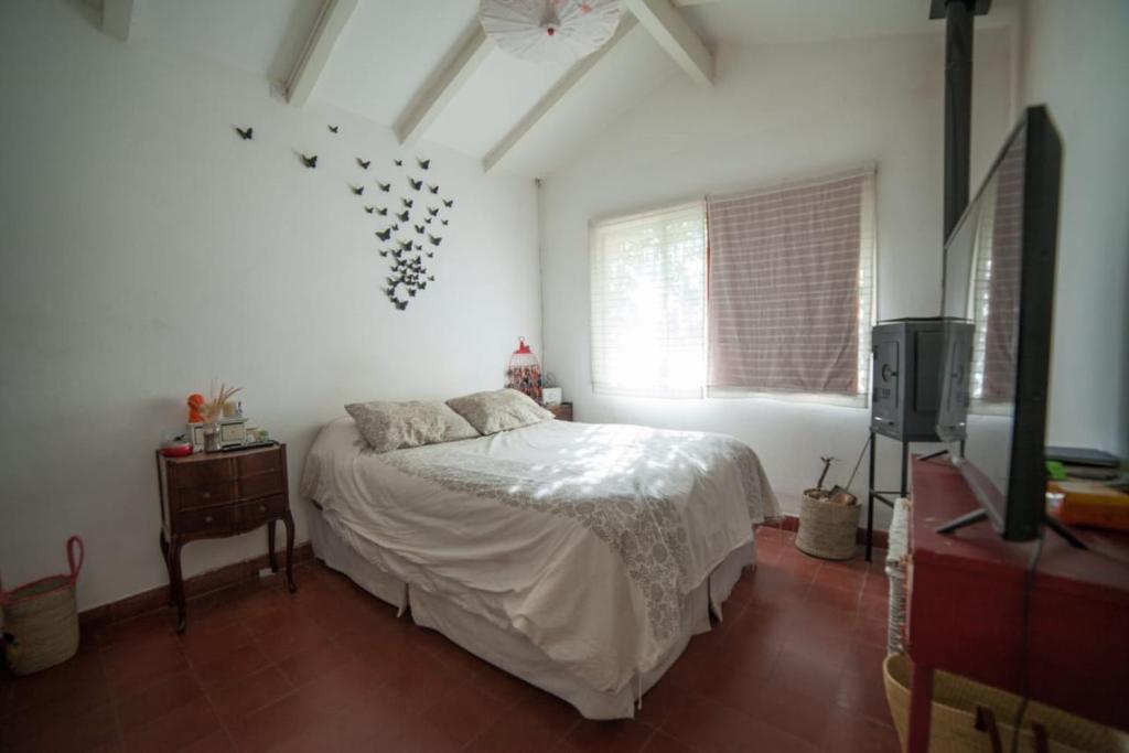 1 dormitorio con 1 cama y TV. en Amoroso Chalet con súper jardín en Los Cocos