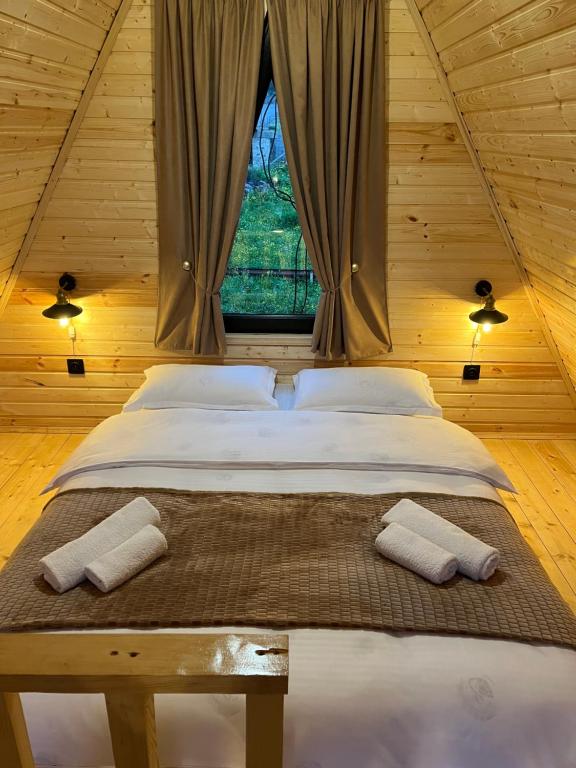 a large bed in a room with a window at Cottage Carpe Diem in Stepantsminda